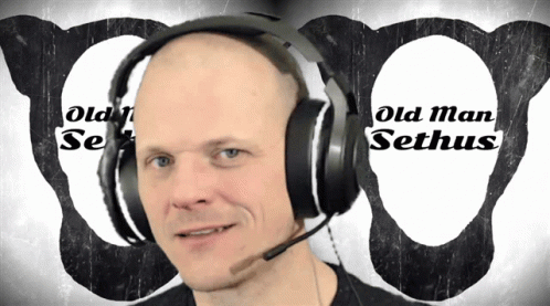 an old man is talking on headphones with the logo behind him