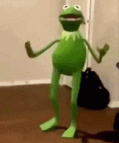 frog with a suit on standing in the corner of a room