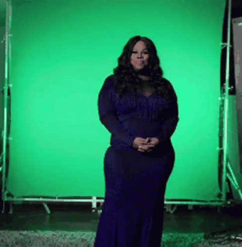 a woman standing in front of a green screen