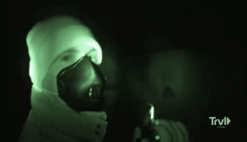 the face of a man in a gas mask holding a gun