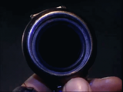 a hand holds an object that looks like it has its camera lens pointed down