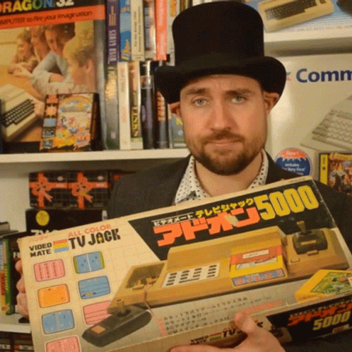 a man holding an old game controller and box in his hands