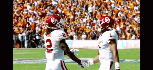 two football players shaking hands on the field