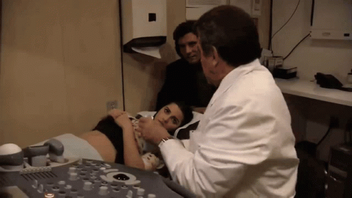 two doctors looking at a woman in the hospital