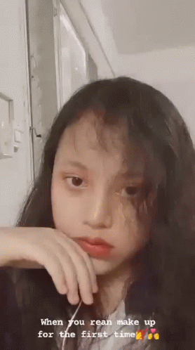 an asian woman looking down at the camera while she's on a video chat