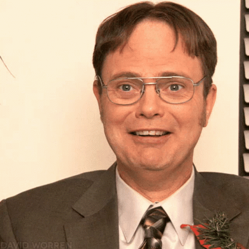 a man with glasses, a suit and a tie with flower