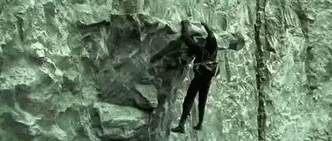 an image of someone climbing up the side of a rock