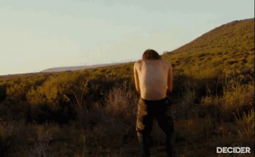 a man is walking along an arid mountain range