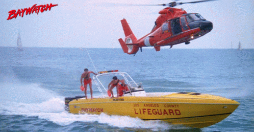 a helicopter flying over the side of a speed boat
