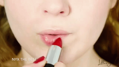 a woman's face with a lipstick stick in her hand