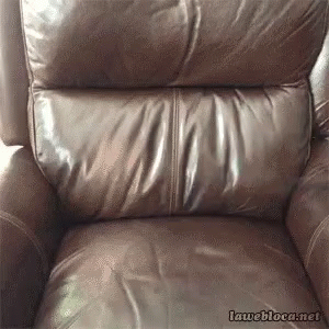an upholstered recliner sits in the corner of the room