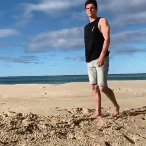 a man in shorts is standing on the beach