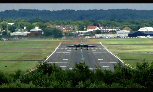 a military jet landing on an airport runway