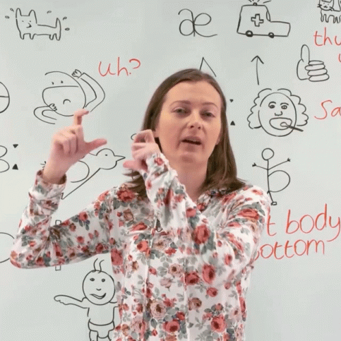 the woman is standing up in front of a whiteboard with writing on it