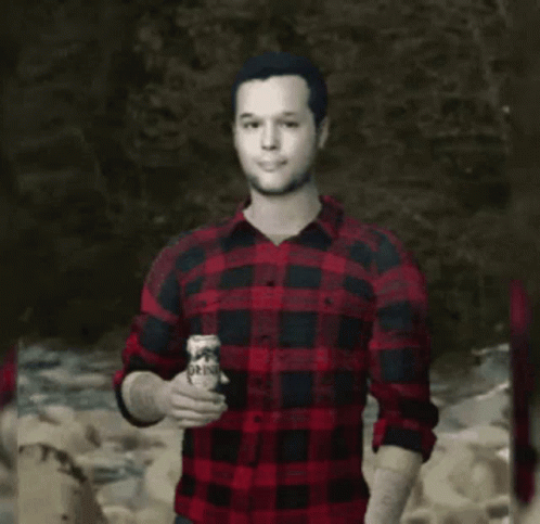 man in checkered shirt holding a can of beer