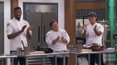 three cooks standing on a counter giving the finger signs