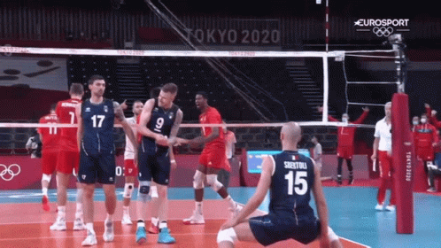 a volley ball game with a man on the ground