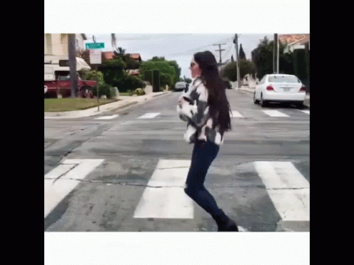 a woman crossing a street at an intersection