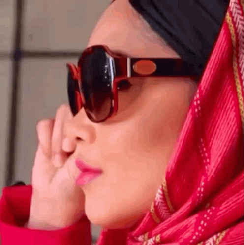 a woman wearing sunglasses is wearing a scarf