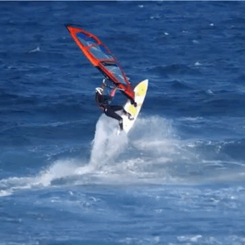 a person holding a surf board and falling from a parachute over the water