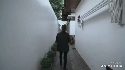 a man is walking down a narrow hallway