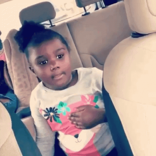 a black little girl sitting in a car seat