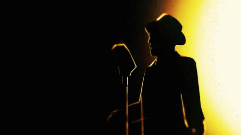 a man with a microphone in the dark