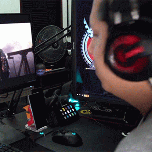 there is a desk that has two monitors and headphones on it