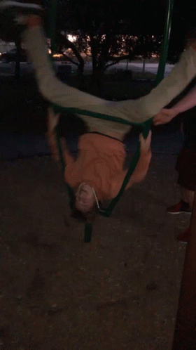 a person swinging upside down on a rope