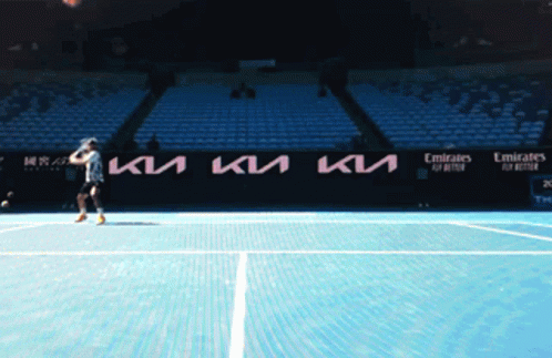 a tennis player stands in front of an empty stadium