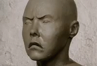 a weird sculpture of a man with his head partially up