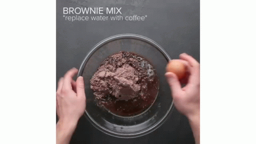 two hands holding a bowl of brownie mix
