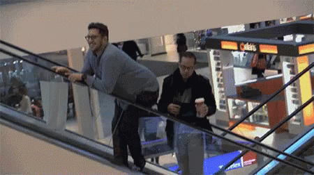two men on an escalator near boxes of packages