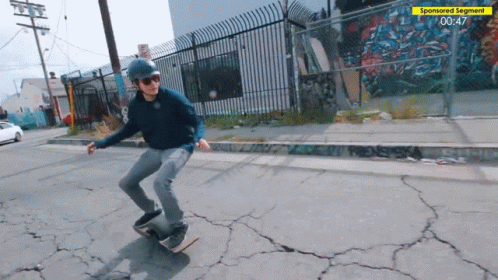 a man wearing blue face paint skateboards down a sidewalk