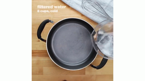 an iron cooking pot with a whisk next to it