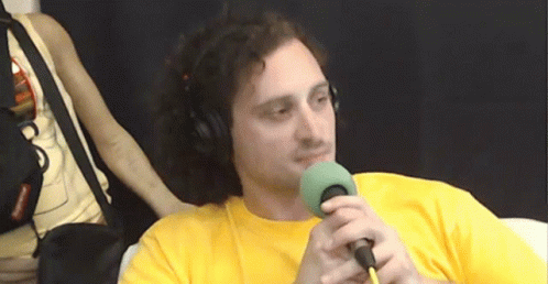 a young man wearing headphones is talking into a microphone