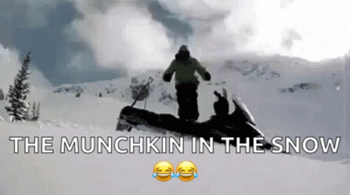 a man riding a snowmobile down a snow covered slope
