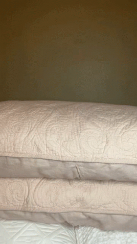 pillows stacked on top of each other in bed