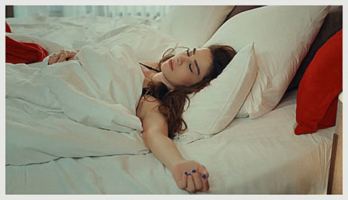 a woman in white dress laying on a bed
