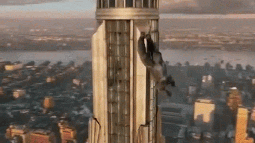 the bird is flying over a very tall building