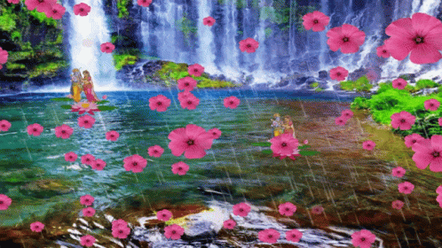 flowers in front of a waterfall with a person
