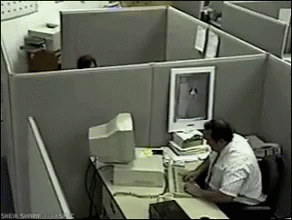 a person on a computer at an office cubicle