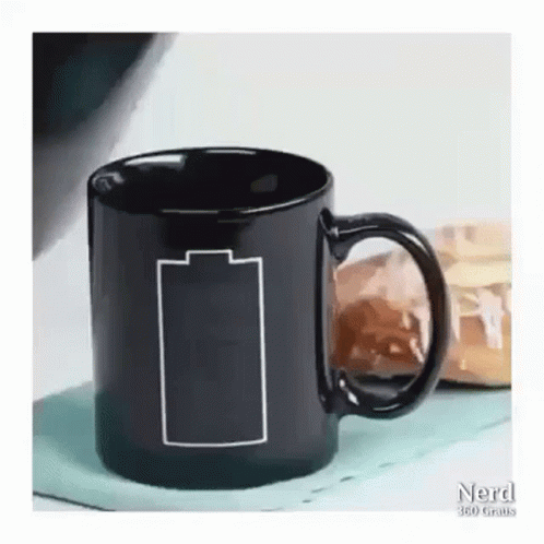 the black coffee cup is on the table with two blue bags