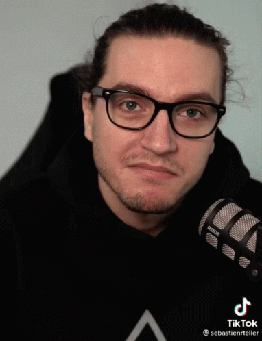 a man with a microphone is wearing glasses