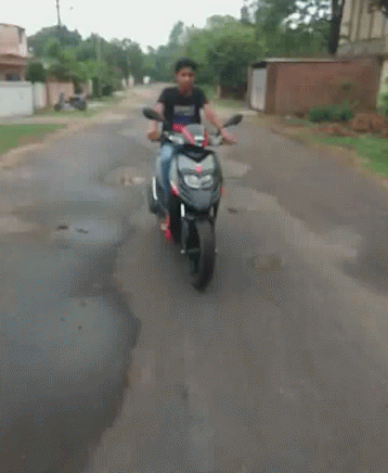 man riding a motorcycle down a city street