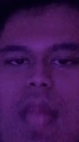 a man in a purple po looks into the camera