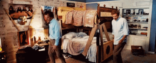 two men in an antique clothing store standing around the bunkbed