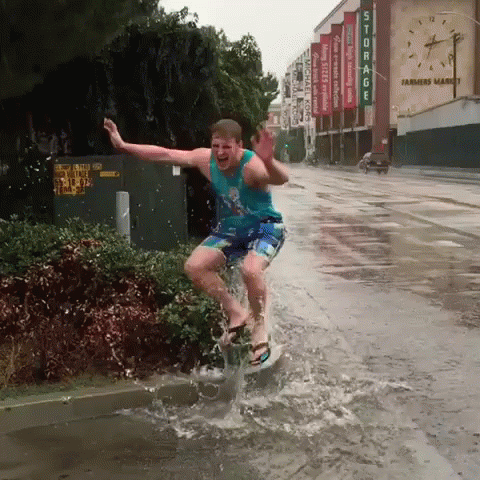 a boy dressed in a yellow shirt jumping into the water