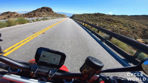 a view from the back seat of a motorcycle of a long road