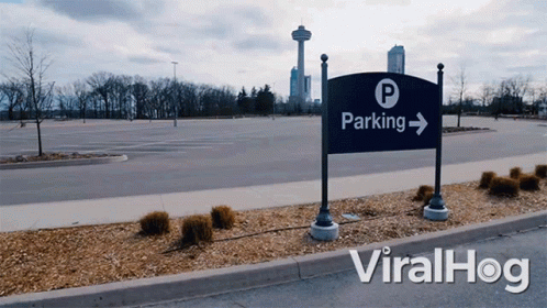 the parking sign is located at the entrance to an empty parking lot